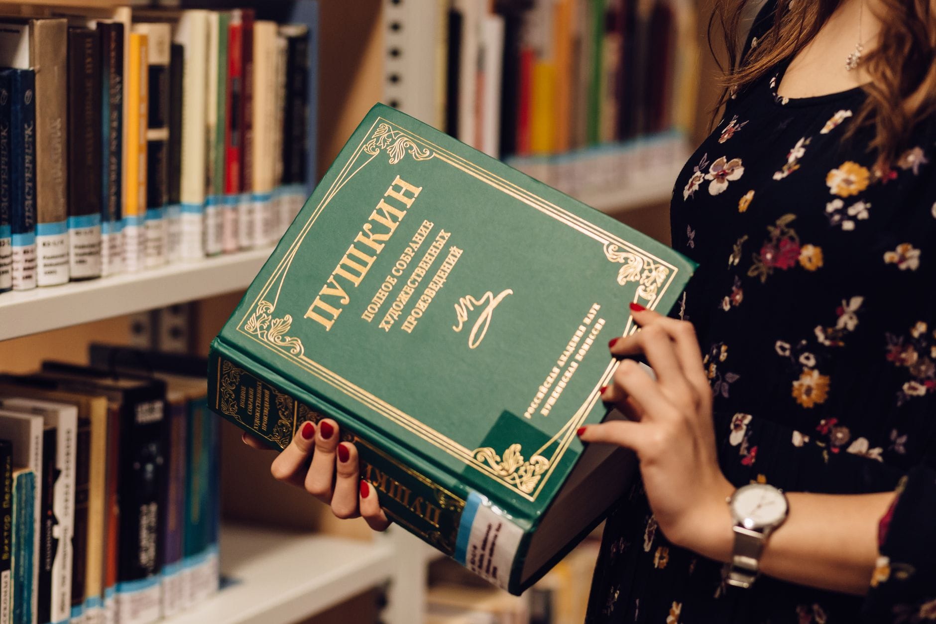 Kobieta z książką rosyjskiej literatury w bibliotece