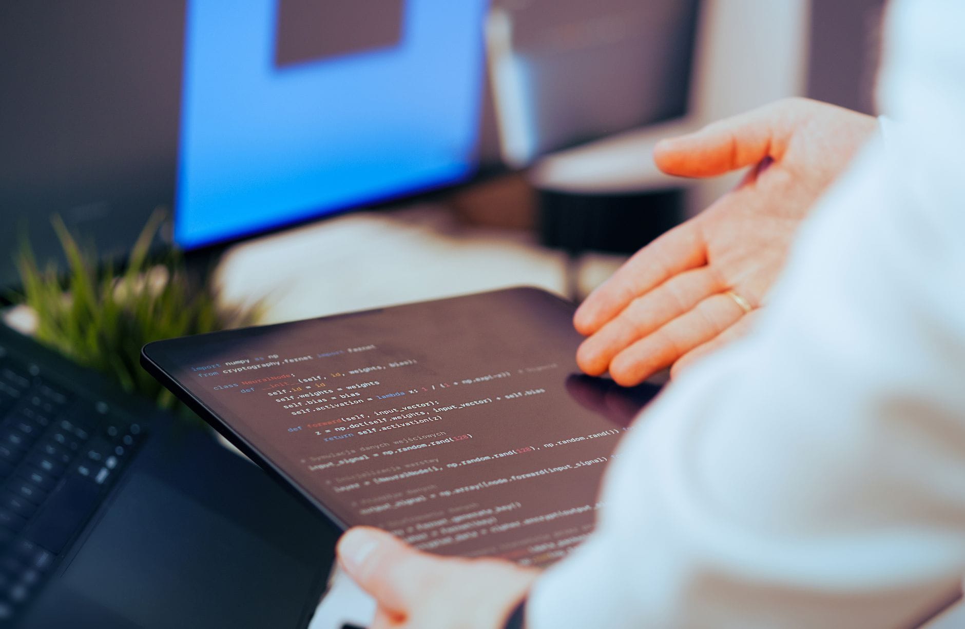 Praktyczne zastosowania modeli językowych w automatyzacji pracy programisty i analityka danych Programista analizuje kod na tablecie w nowoczesnym biurze